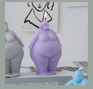 Detail of creative female body shape candles with purple wax and burning flame