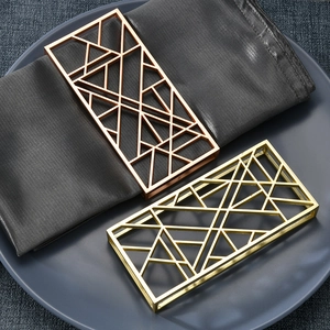 Detailed view of hollow geometric napkin rings in gold and rose gold metal finishes