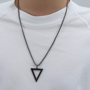 Close-up of black titanium steel triangular pendant necklace on a white t-shirt
