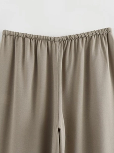 Detail of the elastic waistband and textured linen-blend fabric on khaki trousers
