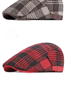 Close-up of red plaid flat cap featuring a metallic adjustable side buckle and thick wool