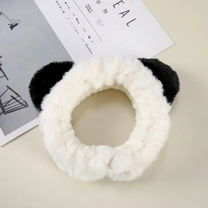 Detailed close-up of a plush panda-ear headband in soft black and white faux fur