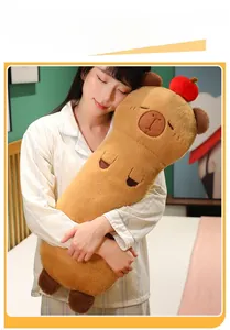 Macro shot of long plush capybara body pillow with a red apple decor on head