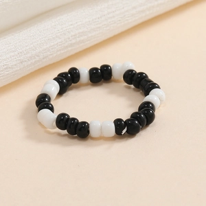 Dettaglio di anello elastico con perline alternate nei colori bianco e nero
