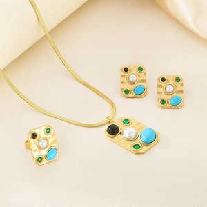 Macro detail of vintage gold-plated jewelry set with turquoise and pearl inlays