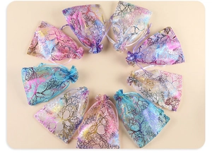Detailed macro view of colorful organza drawstring gift bags with shiny branch patterns