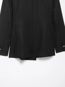 Detailed macro view of the black wool blend twill fabric and decorative metal buttons