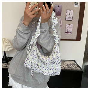 Detail of floral canvas tote bag featuring pleated cloud straps and drawstring accents