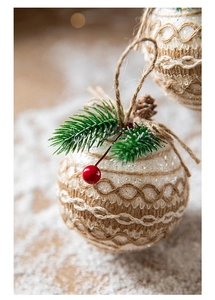 Detail of burlap Christmas ball with white lace, pine needles and red berries