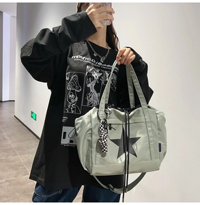 Detailed street style view of a water-resistant light green star tote with drawstring