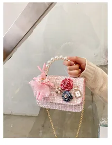 Detailed view of pink tweed kids bag with pearl handle and cute rabbit charm decoration