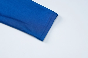 Dettaglio del polsino blu reale con cuciture a doppio ago precise e tessuto a maglia