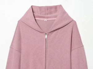 Détail du sweat à capuche zippé rose poudré montrant la texture du tissu et le col