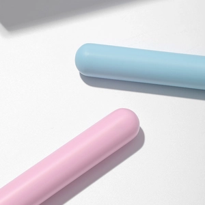 Detail shot of pastel pink and blue makeup brush handles with smooth silicone texture