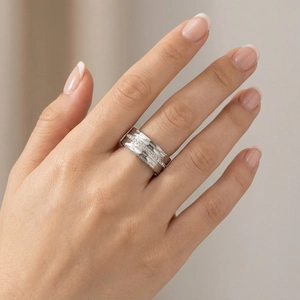 Close-up of silver hammered wide band ring with small diamonds on a model's finger