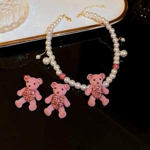 Pink flocked bear jewelry set featuring pearl necklace and crystal stud earrings