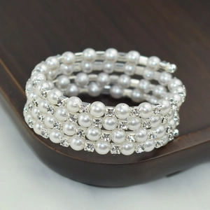 Elegant multi-layer bracelet featuring white pearls and rhinestones on wood tray