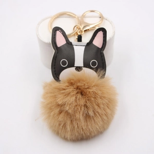 Close-up of fluffy French Bulldog keychain with faux fur pom pom and gold metal clasp