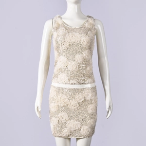Detail of sequined crop top and mini skirt set with 3D floral accents in champagne