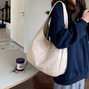 Seitenansicht der beigen Shopper-Tasche mit Lederetikett und weicher PU-Lederstruktur