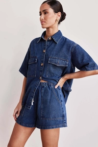 Detail of dark blue denim set featuring short-sleeve button shirt and drawstring shorts