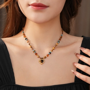 Close-up of vintage beaded heart necklace with turquoise and tiger eye stones
