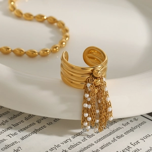 Elegante anello multistrato in acciaio al titanio dorato con nappine di perle pendenti