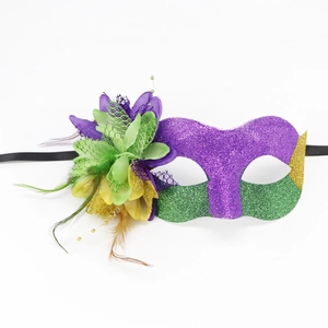 Detailed view of carnival mask with purple feathers, green sequins, and gold beads