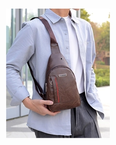 Brown faux leather chest bag with red stripe zip pocket worn by a model in outdoor light
