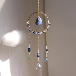 Detail of golden ring suncatcher with blue stone and faceted crystal prism ball