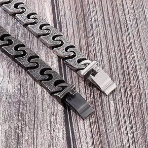 Macro detail of retro industrial chain bracelet showing matte silver and black metal textures