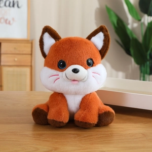 Close-up of cute plush fox toy with orange and white fur on a wooden background