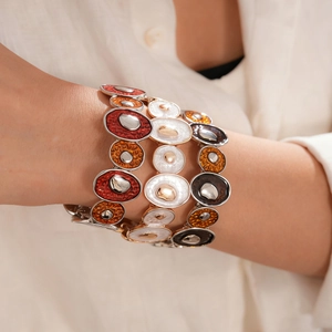 Bracelets bohèmes en émail coloré avec détails métalliques sur manche en lin blanc