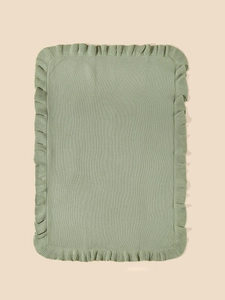 Detail of sage green knitted baby blanket with delicate ruffle edges and soft texture