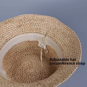 Close-up of raffia sun hat interior showing adjustable drawstring and sweatband