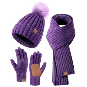 Detailed view of purple knit winter set featuring a faux fur pompom hat and warm scarf