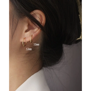 Detail showing 10mm and 12mm gold seamless hoop earrings on model ear for size comparison