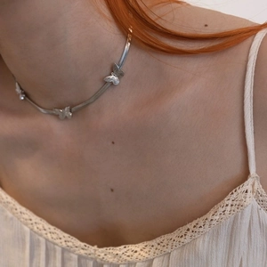 Minimalist silver titanium steel butterfly pendant necklace on model's collarbone