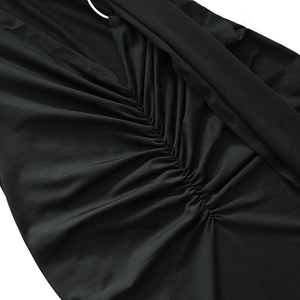 Detail view of black ruched fabric texture with a central silver metal ring connector