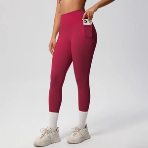 Detail shot of high-waist yoga pants with side pocket holding a white smartphone