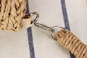 Détail d'un sac en corde de papier tressé avec fermoirs mousquetons en métal argenté