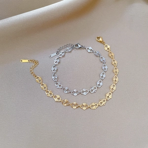 Detailed close-up of interlocking gold and silver pig nose chain bracelets with lobster clasp