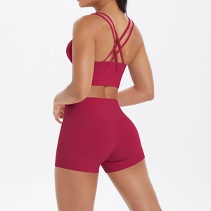 Détail de la brassière de yoga à dos croisé et du short de fitness taille haute rouge