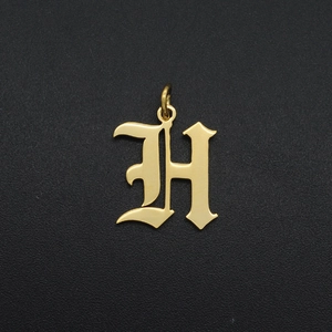 Macro shot of gold Gothic letter H pendant with a polished finish for DIY jewelry