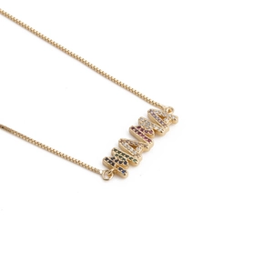 Detailed close-up of gold MAMA necklace featuring rainbow zircon gemstones on white background