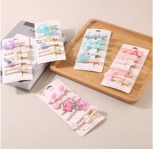 Détail d'un ensemble de pinces à cheveux colorées avec perles sur un plateau en bois
