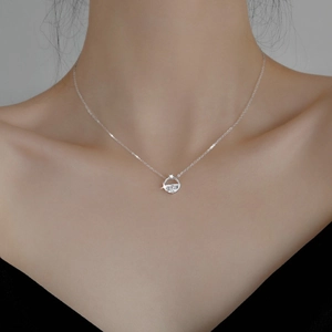 Elegant silver pendant necklace with clear crystal inlay shown on a model's collarbone