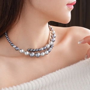 Vue détaillée d'un collier de perles dégradées grises à double rangée, design ouvert