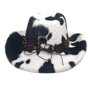 Detail of cow print cowboy hat with plush texture, leather band and golden metal studs