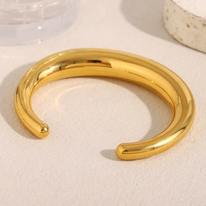 Detailed view of chunky 18K gold plated hollow bangle with pointed ends and polished finish